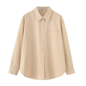 Close-up detail of beige linen shirt showing collar, front pocket and fabric texture