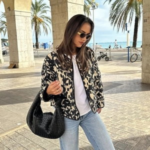 Veste matelassée léopard pour femme avec boutons pression et sac tissé dans une rue d'Europe