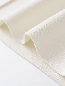 Close-up of premium off-white ribbed knit fabric texture and high-quality stitching