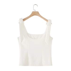 Detail view of a white camisole top featuring elegant shoulder bow ties and side zipper