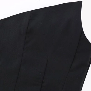 Dettaglio del top a fascia asimmetrico nero con cuciture precise e trama del tessuto