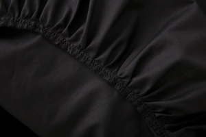 Detail of black V-neck midi dress featuring elasticated ruched fabric and neat stitching