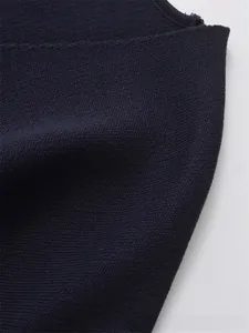 Macro shot of navy blue knit fabric showing fine needlework and rolled edge seam detail