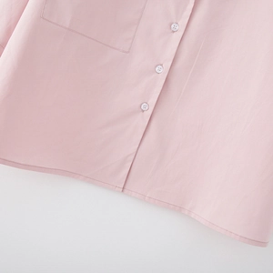 Close-up of pink long-sleeved shirt featuring a pocket, buttons and neat double-stitched hem