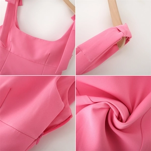 Detail view of pink camisole with bow shoulder straps, side zipper, and textured fabric