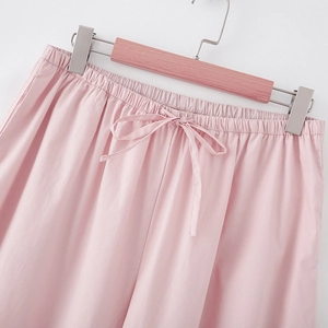 Detail view of pink elastic waistband with drawstring on casual linen-textured pants