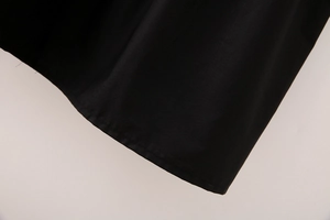 Close-up detail of the smooth hemline and double-needle stitching on black midi dress