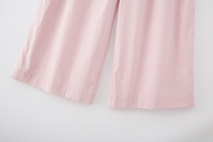 Detail of pink wide-leg pants showing breathable cotton texture and fine stitching finish