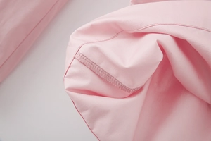 Detailed close-up of pink fabric interior stitching and high-quality hemmed edge finish