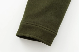 Detail of dark green wool coat cuff showing fine stitching and premium texture