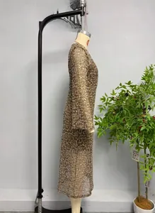 Macro shot of bronze sequins on long sleeve mesh dress showing metallic texture