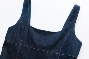 Detailed view of dark blue denim dress featuring square neckline and orange topstitching