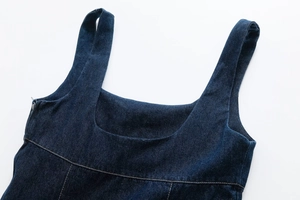 Detail of dark blue denim dress showing square neckline and contrast stitching