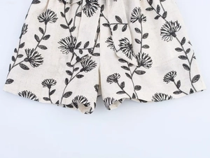 Détail du short en coton et lin avec imprimés floraux noirs et ceinture à nouer