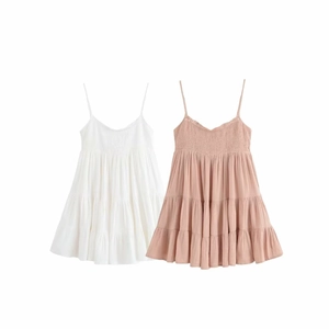 Détails du corsage froncé et des jupes à volants sur robes blanches et roses