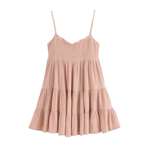 Détail de la robe rose clair à volants avec bustier smocké et finitions en dentelle
