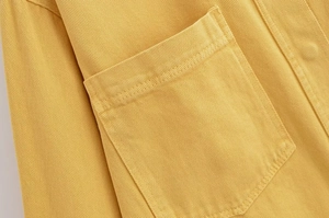 Détail de la veste en sergé de coton jaune gingembre montrant la poche plaquée et la couture