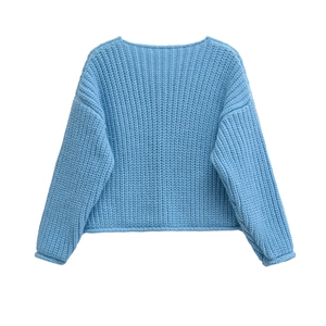 Detailed close-up of light blue chunky knit texture on long sleeve crewneck sweater