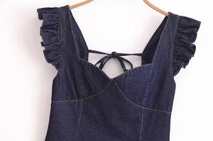 Detaillierte Nahaufnahme von dunkelblauen Denim-Rüschen und herzförmigem V-Ausschnitt mit Naht