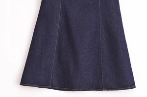 Detail eines dunkelblauen Jeans-Minirocks mit kontrastreichen orangefarbenen Nähten