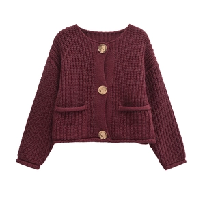 Detailed view of burgundy chunky knit cardigan with gold buttons and ribbed texture