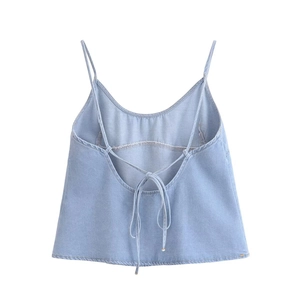Detailed view of light blue denim camisole featuring thin straps and crisscross lace-up back