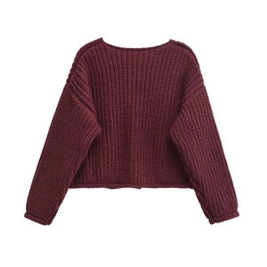 Detail view of burgundy chunky knit sweater showing rib-knit cuffs and thick texture