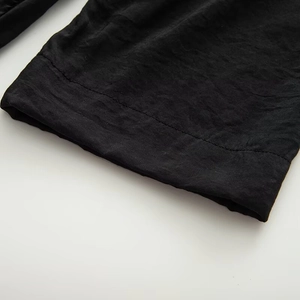 Detailed view of short sleeve cuff with clean stitching on black fabric