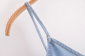 Close-up of light blue denim straps with contrasting yellow stitching detail