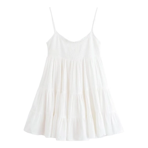 Détail de robe blanche à fines bretelles avec volants étagés et corsage plissé chic