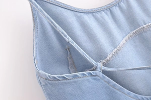 Detailed close-up showing sewing lines and twill texture of a light blue denim top