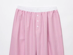 Dettaglio dei pantaloni del pigiama a righe bianche e rosa con vita elastica e bottoni