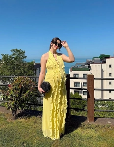 Vue détaillée d'une robe longue jaune avec décolleté en V et volants verticaux