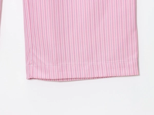 Dettaglio dei pantaloni a righe rosa e bianche con tessuto liscio e cuciture curate