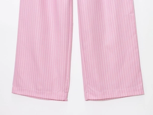 Dettaglio del tessuto a righe verticali rosa e bianche su pantaloni estivi leggeri