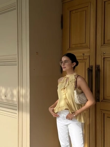 Detail of light yellow halter neck top with layered ruffles and elegant chiffon texture