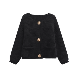 Detail of black chunky knit cardigan featuring vintage round gold metal buttons and pockets