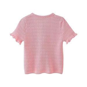 Détail du haut en maille rose avec texture ajourée et bords de manches à volants fins