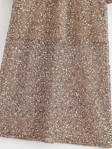 Macro shot of high-density gold sequins sewn on mesh fabric for fashionable dresses