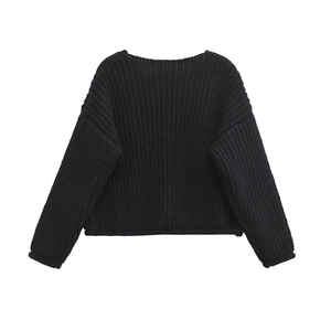 Detailed view of black chunky knit texture on loose-fit long-sleeved crewneck sweater