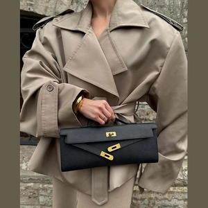 Detail of the golden twist lock and litchi texture leather on the black long clutch