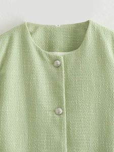 Detail of light green tweed jacket featuring vintage silver buttons and woven texture