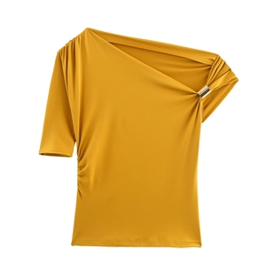 Détail du haut moutarde à épaule dénudée avec anneau métallique et texture de tissu plissé