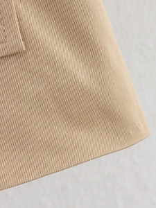 Makroansicht der khakifarbenen Twill-Stoffstruktur und Doppelnähte am Trenchcoat