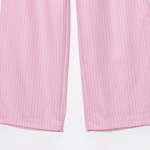 Primo piano dei pantaloni a pieghe a righe rosa e bianche con dettaglio su orlo e tessuto
