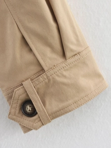 Detailaufnahme der khakifarbenen Trenchcoat-Ärmel mit verstellbarem Riemen und Knopf