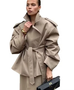 Detail of khaki trench jacket featuring epaulets and a cinched belted waist design