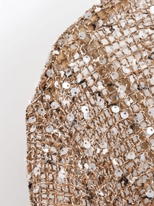 Macro shot of brown knit dress fabric with intricate mesh patterns and shiny sequins