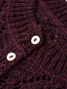Macro shot of burgundy hollow-out knit cardigan with white mother-of-pearl buttons