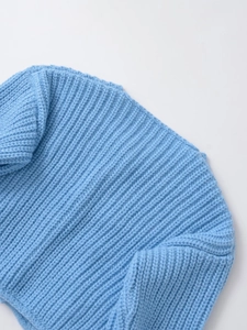 Detail view of sky blue knit sweater showing high-quality ribbed knit texture and soft fabric